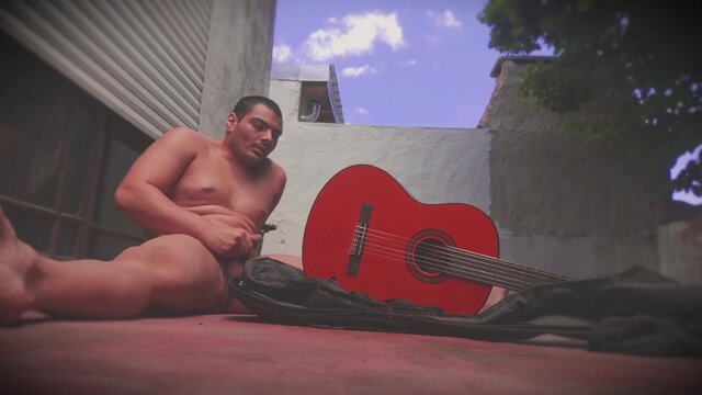 Muscular man rubs enormous shaft against guitar in outdoor solo act